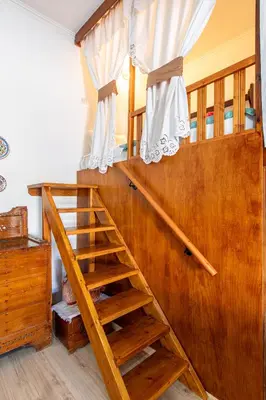 a wooden bunk bed with a staircase in a room at La Casa Lemonià in Soroni