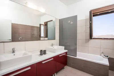 a bathroom with two sinks and a tub and a mirror at Aggelina Pefkos in Pefki Rhodes