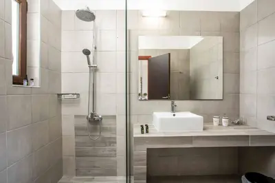 a bathroom with a shower with a sink and a mirror at Aggelina Pefkos in Pefki Rhodes
