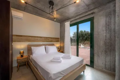 a bedroom with a large bed and a large window at Alki Slow Living Apartments in Rhodes Town