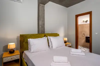 a bedroom with a white bed with two towels at Alki Slow Living Apartments in Rhodes Town