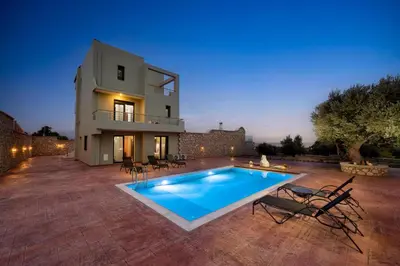a villa with a swimming pool at night at Alki Slow Living Apartments in Rhodes Town