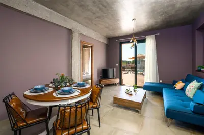 a living room with a table and a blue couch at Alki Slow Living Apartments in Rhodes Town