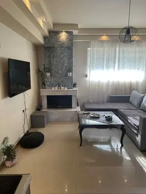 a living room with a couch and a fireplace at Sunny Garden in Koskinou