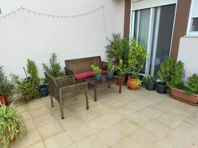a patio with two benches and potted plants at Sunny Garden in Koskinou