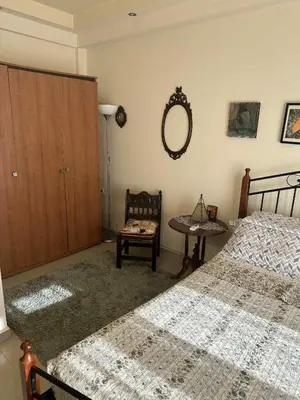 a bedroom with two beds and a table and a mirror at Sunny Garden in Koskinou