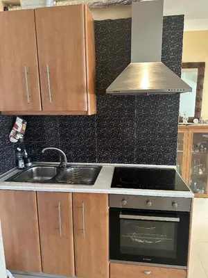 a kitchen with a sink and a stove at Sunny Garden in Koskinou