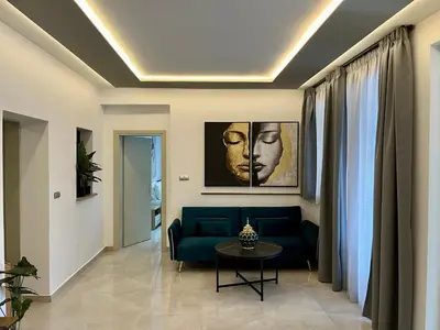 a living room with a blue couch and a table at Casa Loma 2 in Rhodes Town