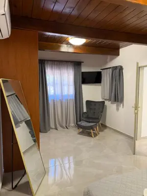 a living room with a mirror and a chair at Casa Loma 2 in Rhodes Town