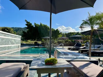 a table with an umbrella next to a swimming pool at Casa Loma 2 in Rhodes Town