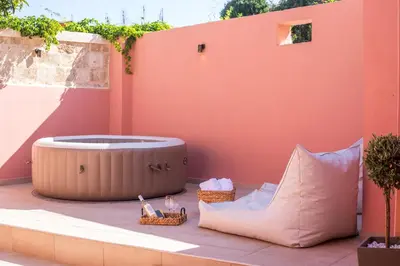 a hot tub sitting on a patio with two baskets at Elysian Suite in Rhodes Town