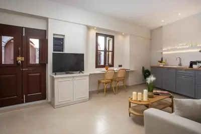 a living room with a couch and a table with a tv at Elysian Suite in Rhodes Town