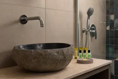 a bathroom with a stone sink and a shower at KIVOTOS BLACK Horse in Pefki Rhodes