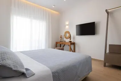 a bedroom with a bed and a flat screen tv at KIVOTOS BLACK Horse in Pefki Rhodes