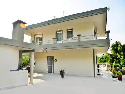 a house with a balcony on top of it at Elegant Villa with Pool & Garden in Eleousis in Kalithies
