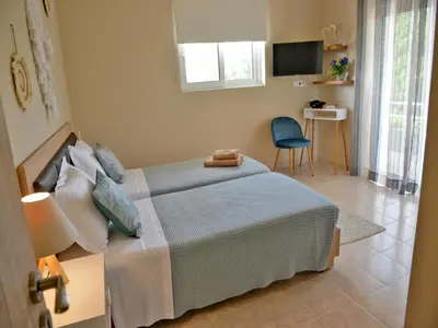 a bedroom with a bed and a table and a chair at Elegant Villa with Pool & Garden in Eleousis in Kalithies