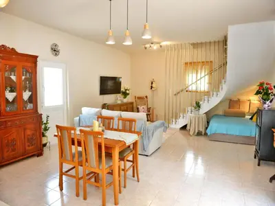 a living room with a table and chairs and a couch at Elegant Villa with Pool & Garden in Eleousis in Kalithies