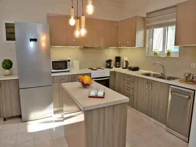 a kitchen with a refrigerator and a counter top at Elegant Villa with Pool & Garden in Eleousis in Kalithies