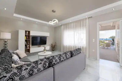 a living room with a large couch and a television at The Cottage South Escape with beach front pool in Plimmiri