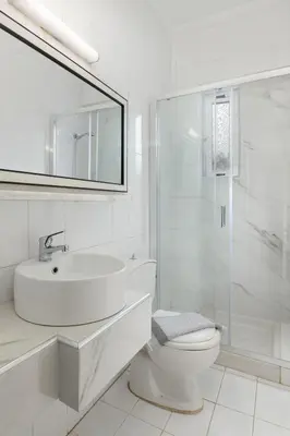 a white bathroom with a sink and a toilet at The Cottage South Escape with beach front pool in Plimmiri