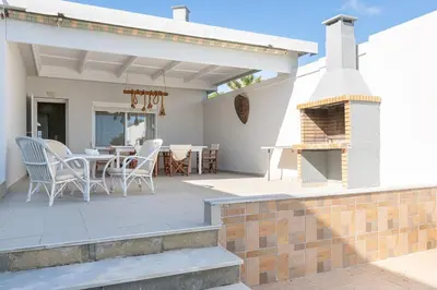 a patio with a table and chairs and a fireplace at The Cottage South Escape with beach front pool in Plimmiri