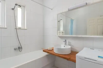 a white bathroom with a sink and a mirror at The Cottage South Escape with beach front pool in Plimmiri