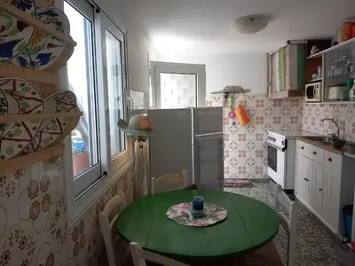 a small kitchen with a table and a green table at Traditionelles Dorfhaus Malona in Malona Village