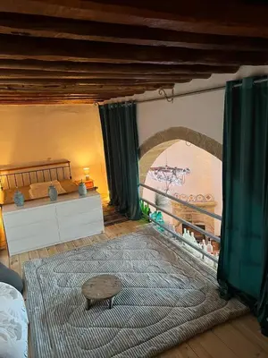 a bedroom with a bed and a table and a rug at Traditionelles Dorfhaus Malona in Malona Village