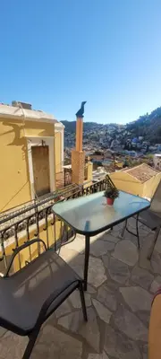 a table and chairs on a balcony with a view at Villa Salachouri in Symi