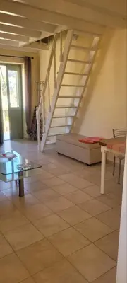 a living room with a bed and a staircase at Villa Salachouri in Symi