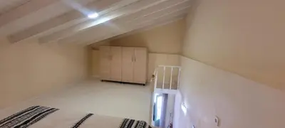 an attic room with a bed and a cabinet at Villa Salachouri in Symi