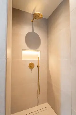 a bathroom with a shower with a light on the wall at Naiades Guest House in Sálakos
