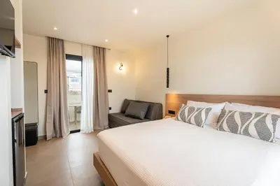 a bedroom with a bed and a chair at Naiades Guest House in Sálakos