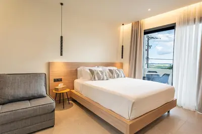 a bedroom with a bed and a couch and a window at Naiades Guest House in Sálakos