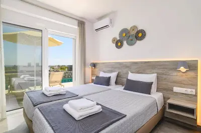 a bedroom with a large bed with towels on it at Villa Amethyst Gem by Villa Plus in Gennadi
