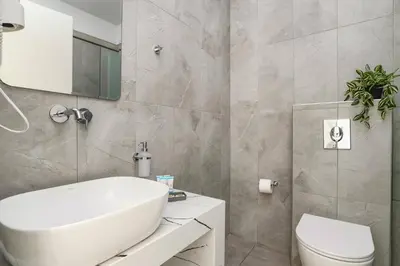 a bathroom with a white sink and a toilet at Villa Amethyst Gem by Villa Plus in Gennadi