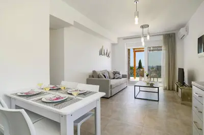 a white living room with a table and a couch at Villa Amethyst Gem by Villa Plus in Gennadi