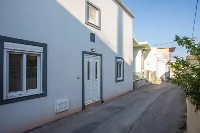 an alley with a white building and a door at La Casa Di Kika in Malona Village
