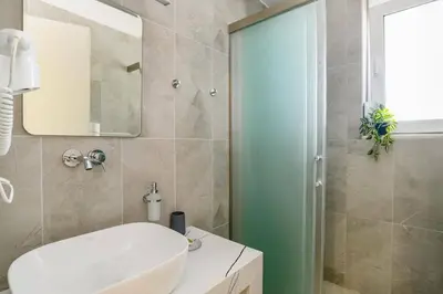 a bathroom with a white sink and a shower at Villa Ruby Gem by Villa Plus in Gennadi
