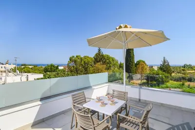 a table and chairs on a balcony with an umbrella at Villa Ruby Gem by Villa Plus in Gennadi