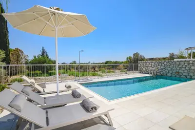 a villa with a swimming pool and an umbrella at Villa Ruby Gem by Villa Plus in Gennadi