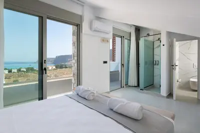 a bedroom with a bed and a view of the ocean at Lindian Poem Villas in Líndos