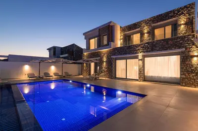 a swimming pool in front of a house at Lindian Poem Villas in Líndos