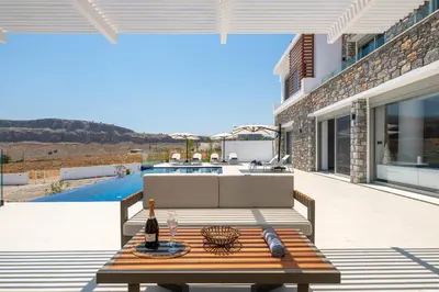 a patio with a bench and a table at Lindian Poem Villas in Líndos