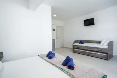 a room with two beds and a couch at Anika Studios Faliraki in Faliraki