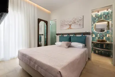 a bedroom with a large bed and a mirror at Kivotos Blue villa in Lardos