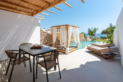 a patio with a table and chairs and a pool at Kivotos Blue villa in Lardos