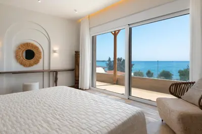 a bedroom with a bed and a view of the ocean at Kivotos Blue villa in Lardos