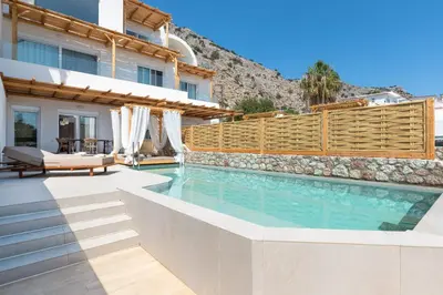 a villa with a swimming pool and a fence at Kivotos Blue villa in Lardos