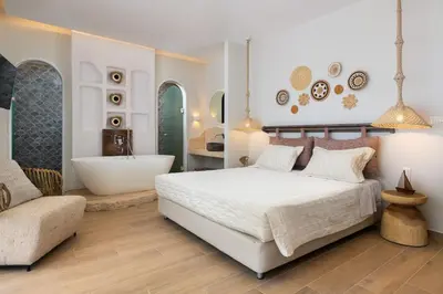 a bedroom with a white bed and a bath tub at Kivotos Blue villa in Lardos